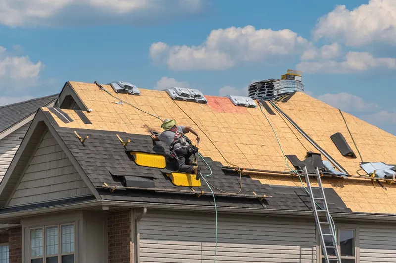 Roofing contractor installing new shingles on a residential roof